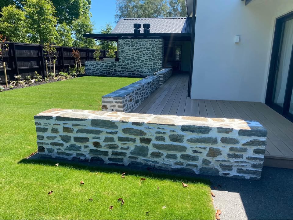 Riverstone wall in front of a modern house