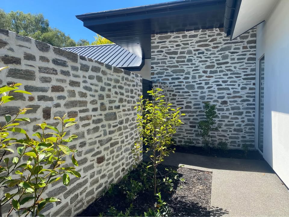 Riverstone wall against a new build